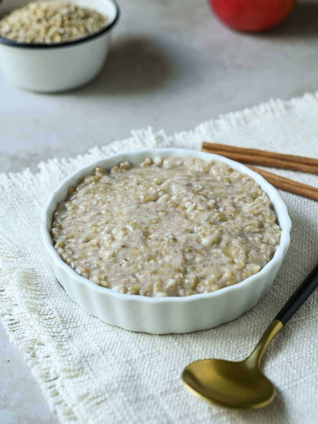 Oatmeal in a white dish with a spoon next to it.