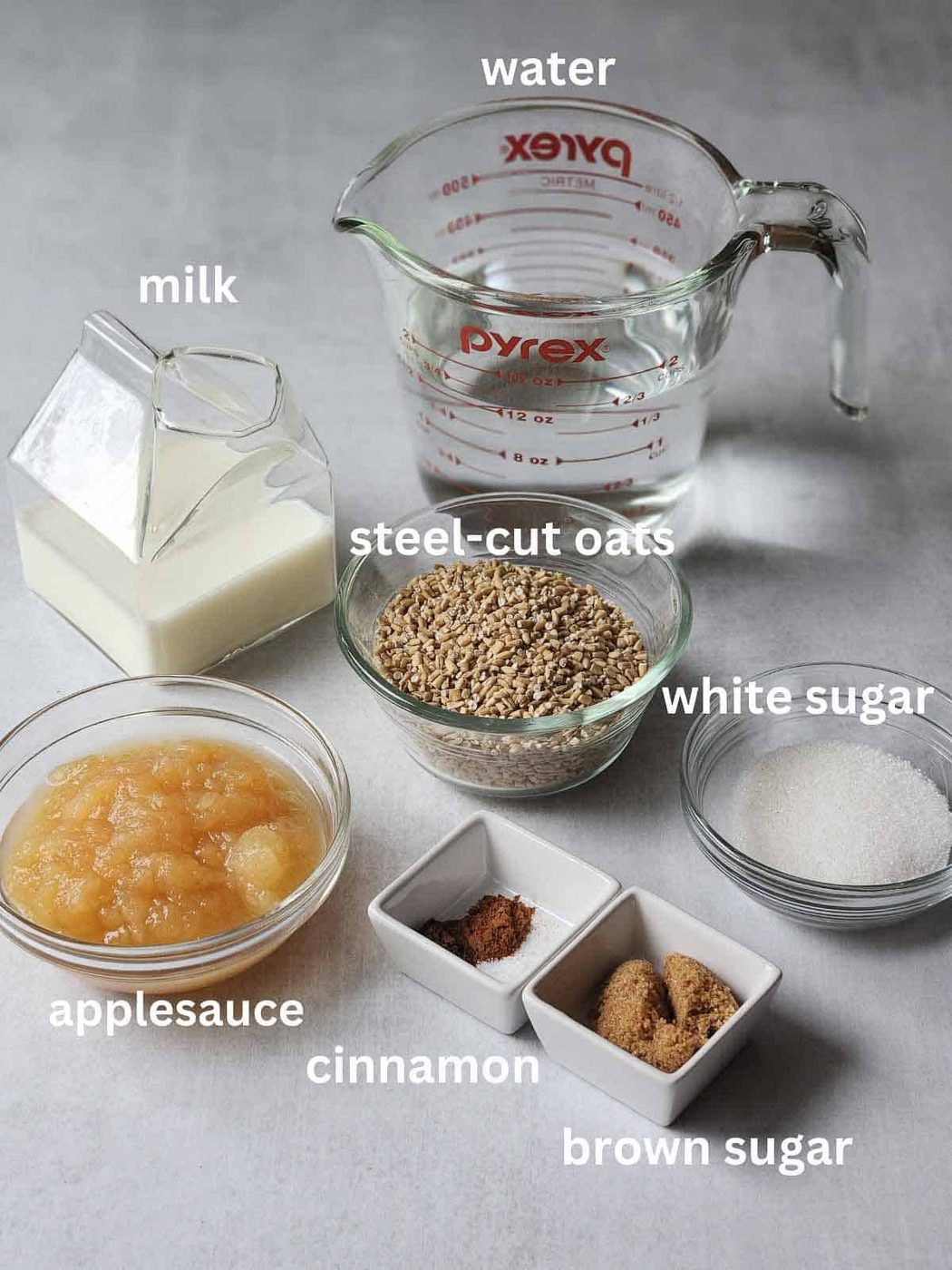 Ingredients on a beige surface for apple pie oatmeal.