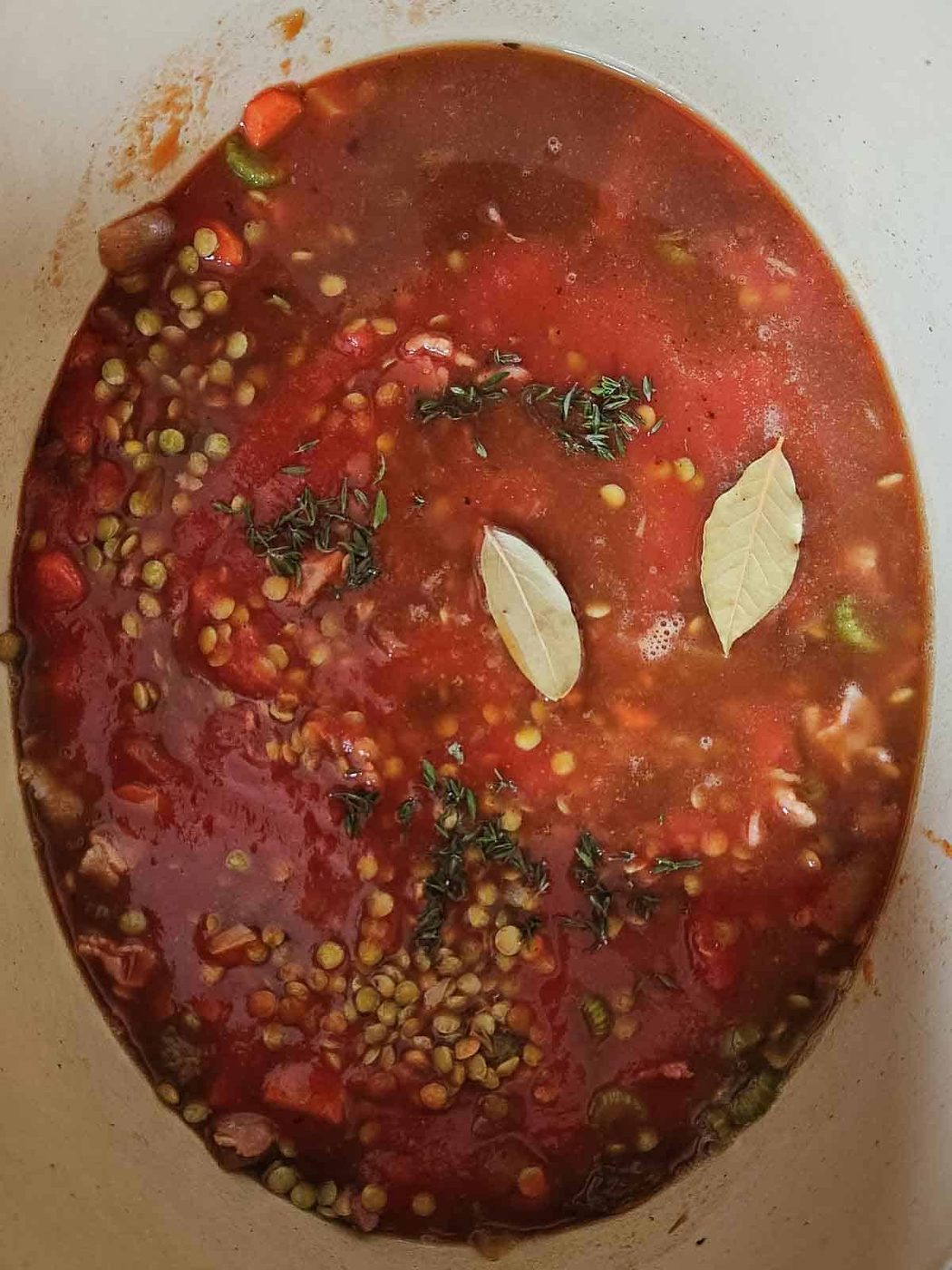 Overview of lentil soup in a pot with tomato sauce.