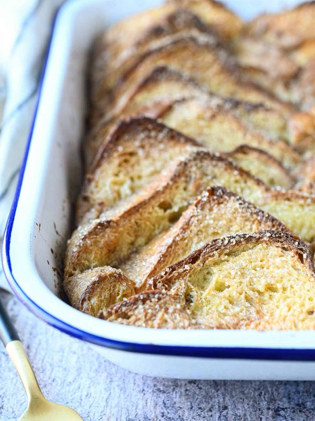 Baked French toast in a white enameled pan.