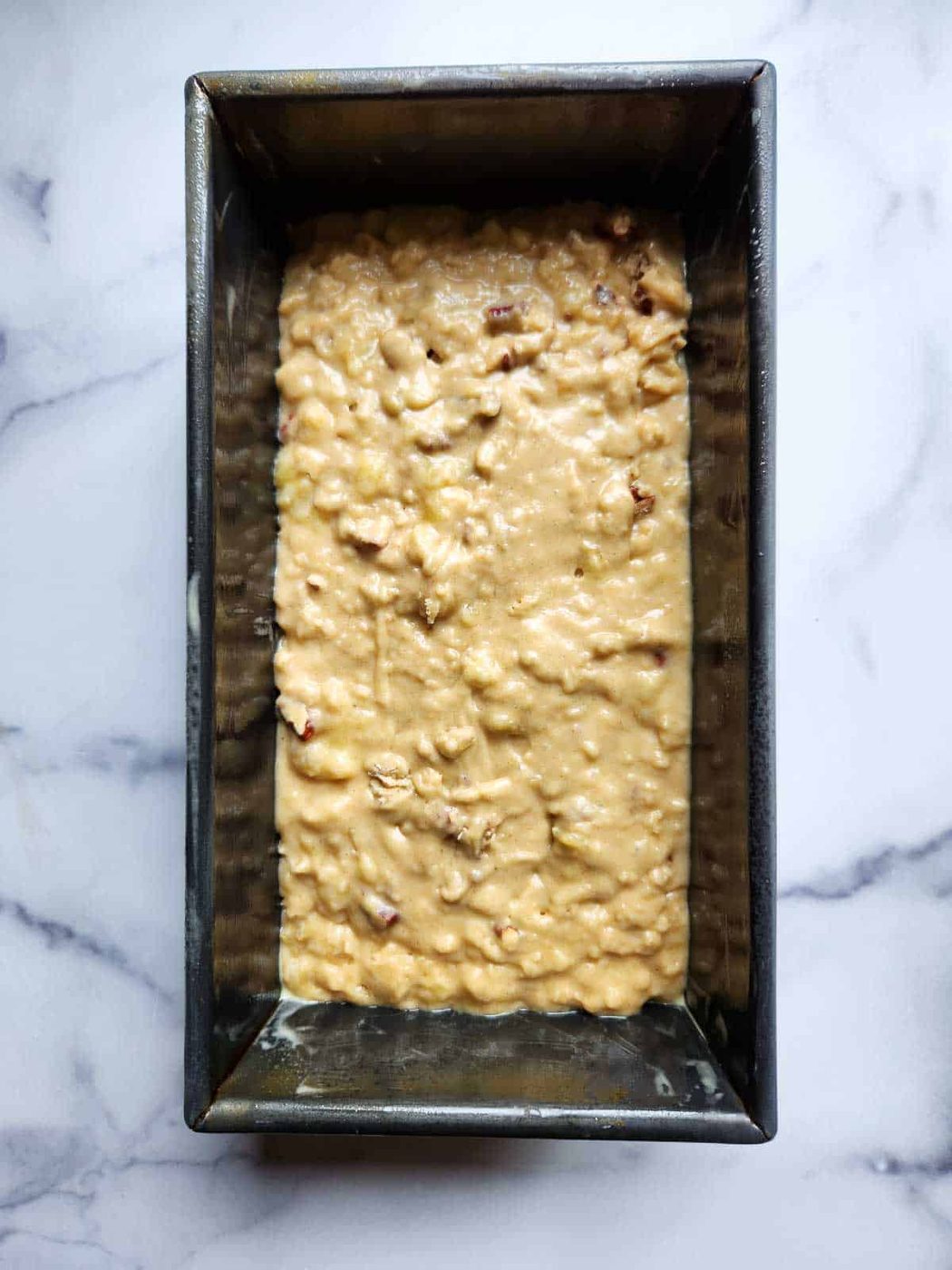 Banana bread batter in a loaf pan.