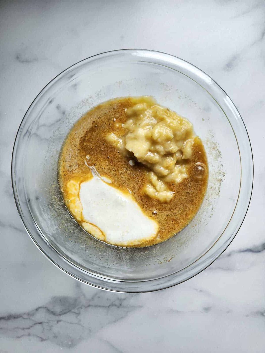Wet ingredients for banana bread in a bowl.