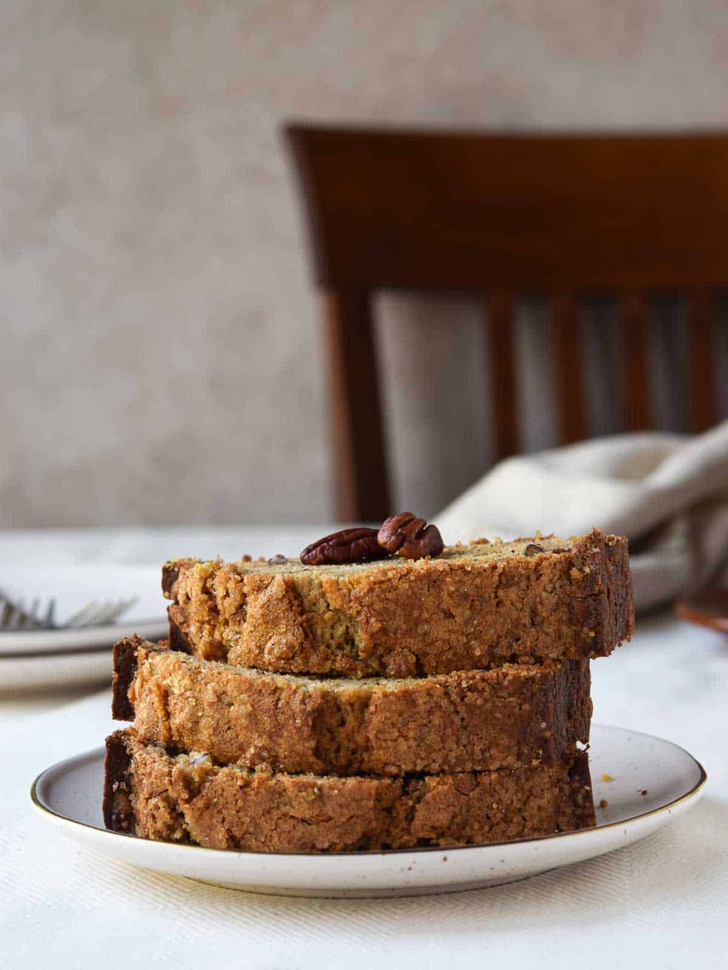 Close-up of banana bread cut and stacked tall on a plate.