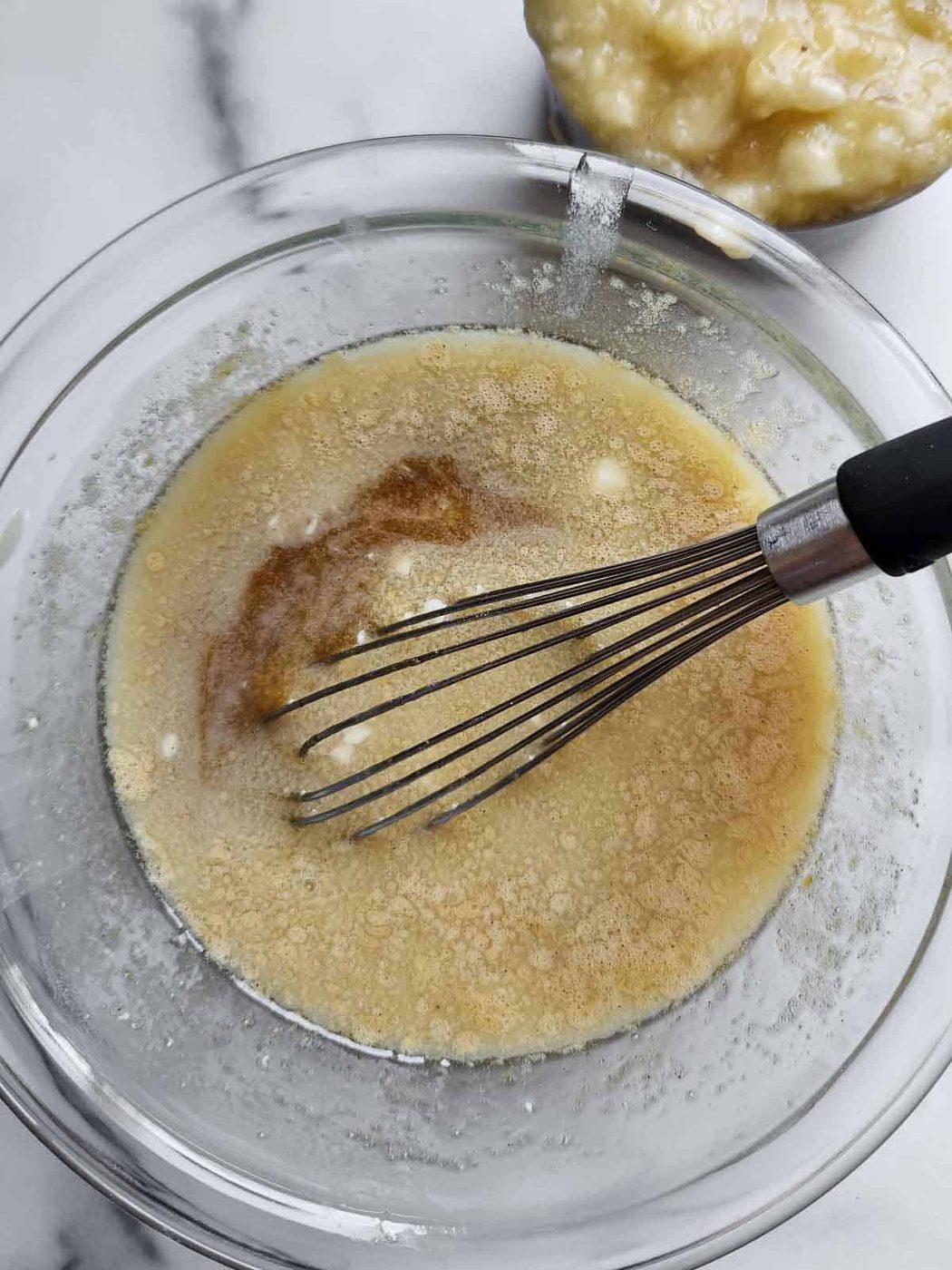Wet ingredients in a bowl for banana muffins.