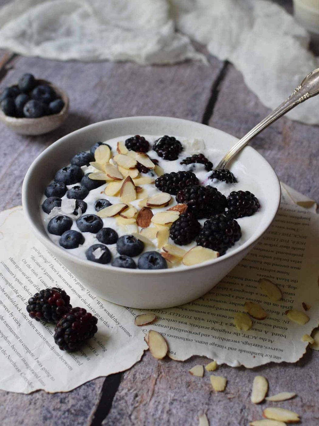 Bowl of whipped cottage cheese with fruit and nuts on top.