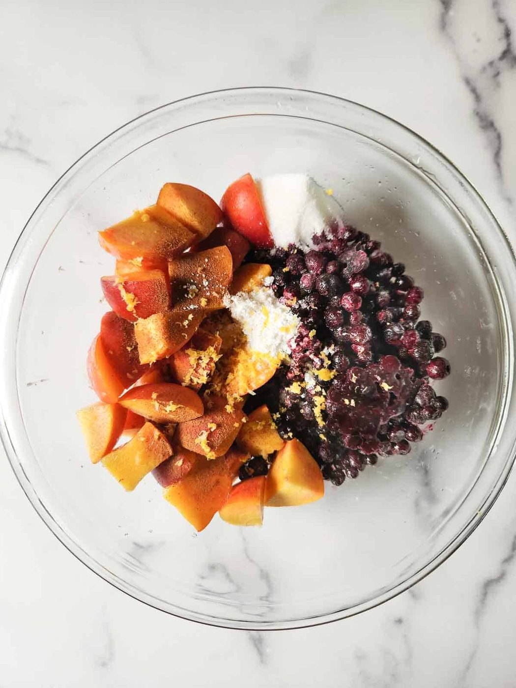 Peaches ad blueberries prepared in a bowl for a crisp.
