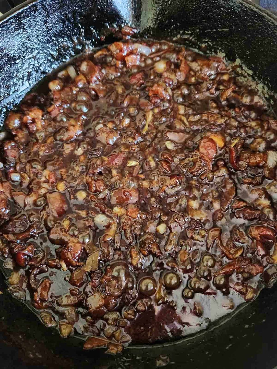 Caramelized bacon chutney cooking in a cast iron skillet.