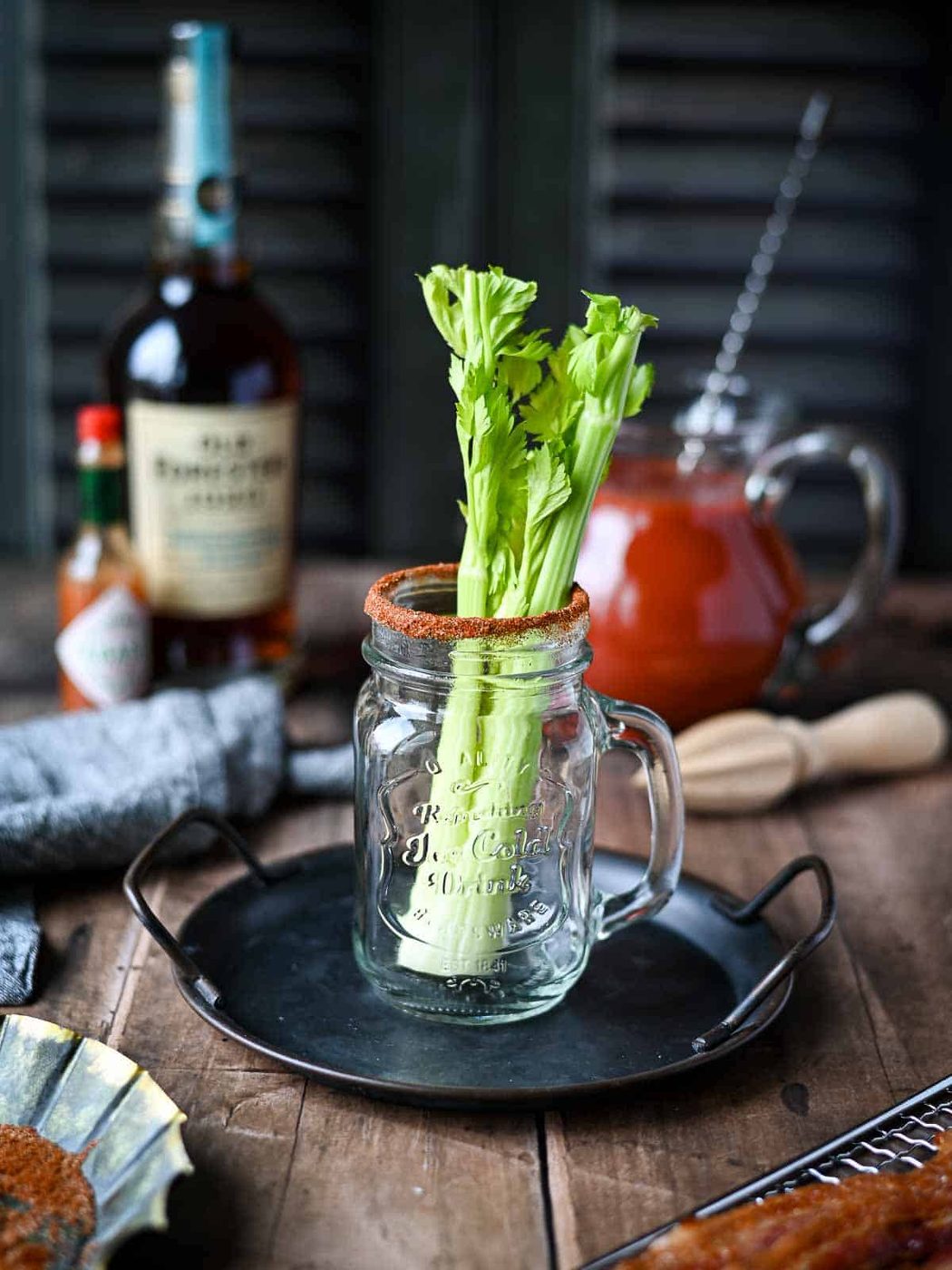 Celery in a Mason glass jar on a wood surface.