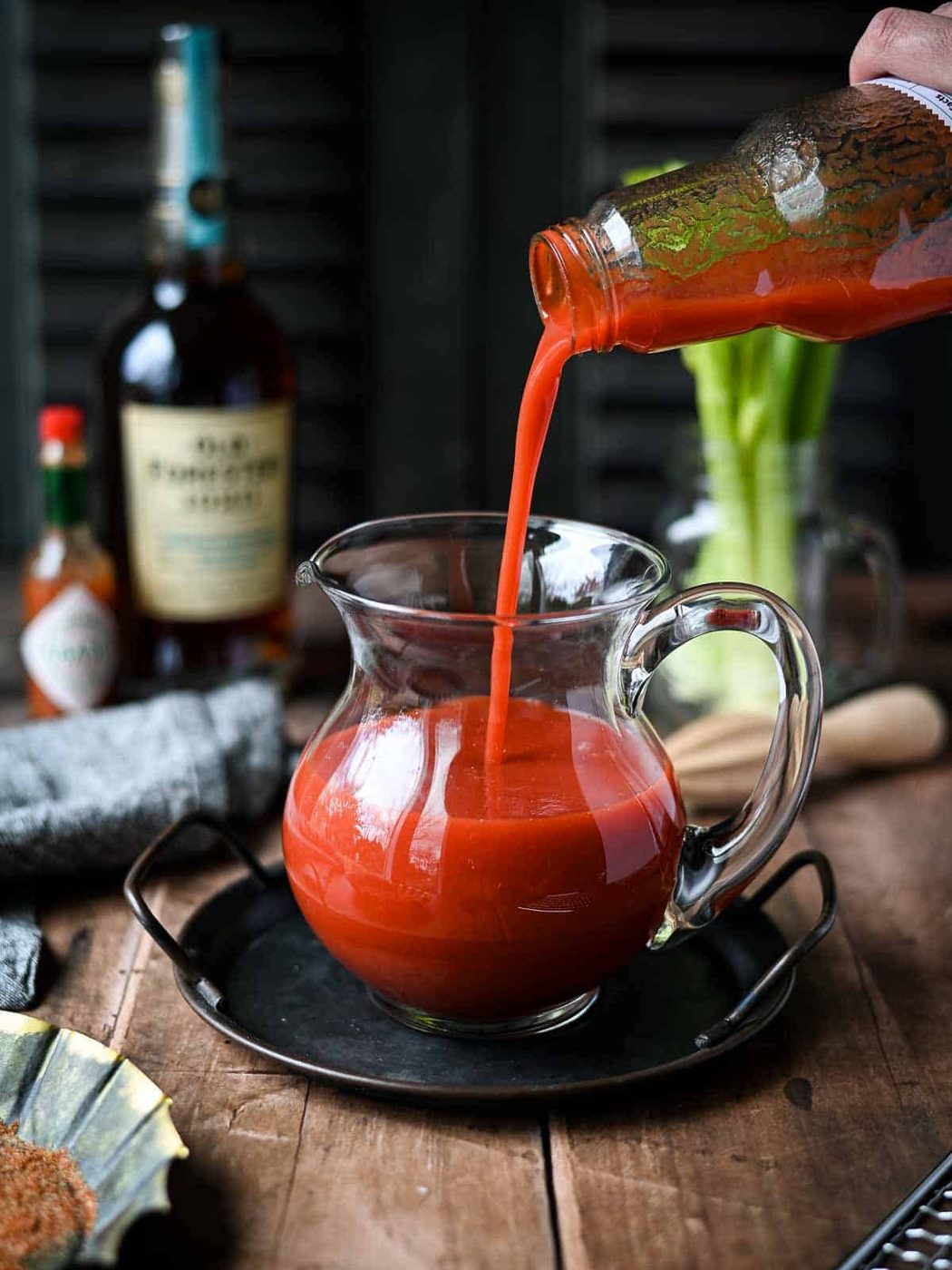Tomato juice being poured into a clear pitcher.