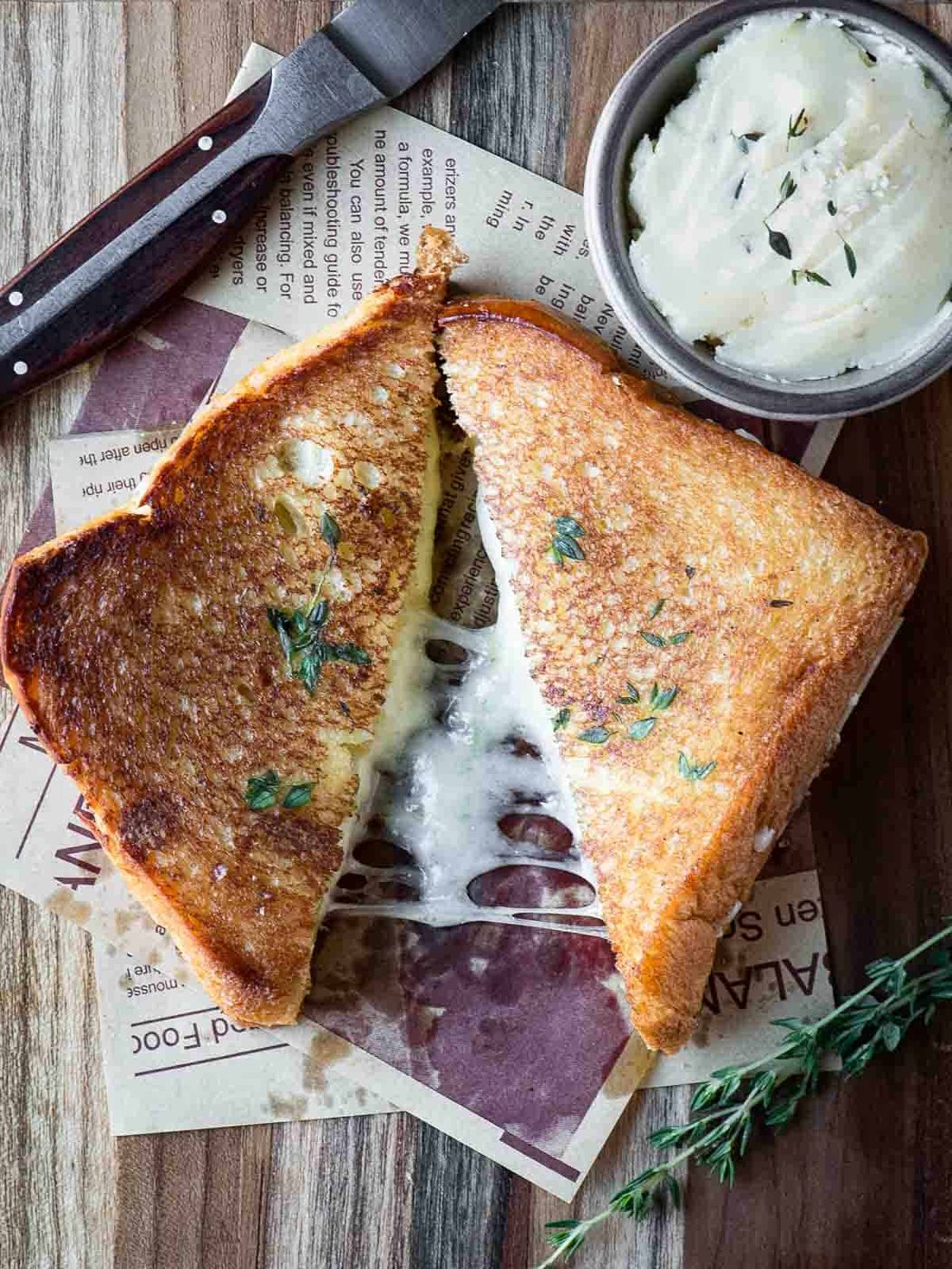 Overhead of a brioche grilled cheese cut in half on a wood surface.
