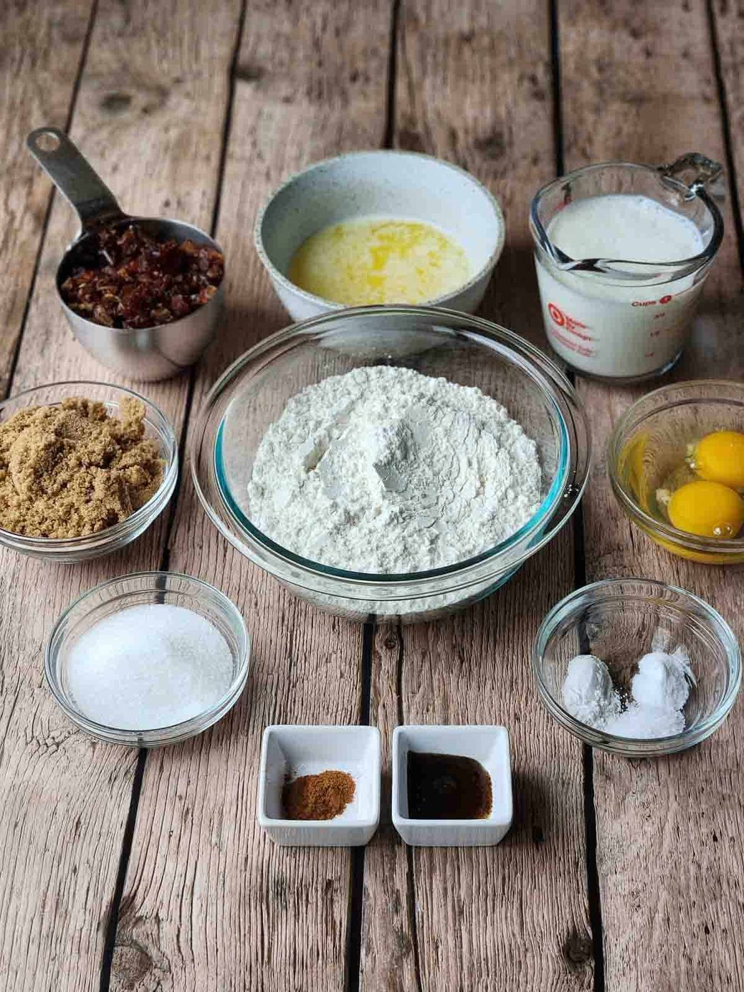 Ingredients for date muffins on a wood surface.