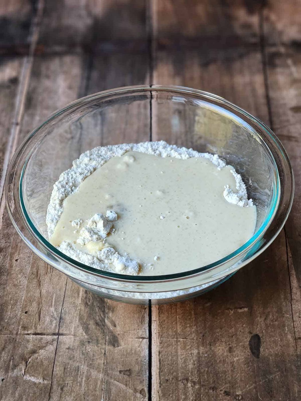 Pancakes batter in a clear bowl.