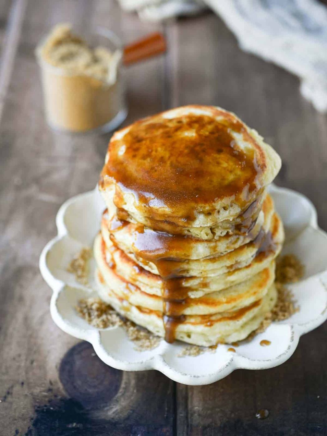 Brown sugar syrup dripping down a stack of pancakes.