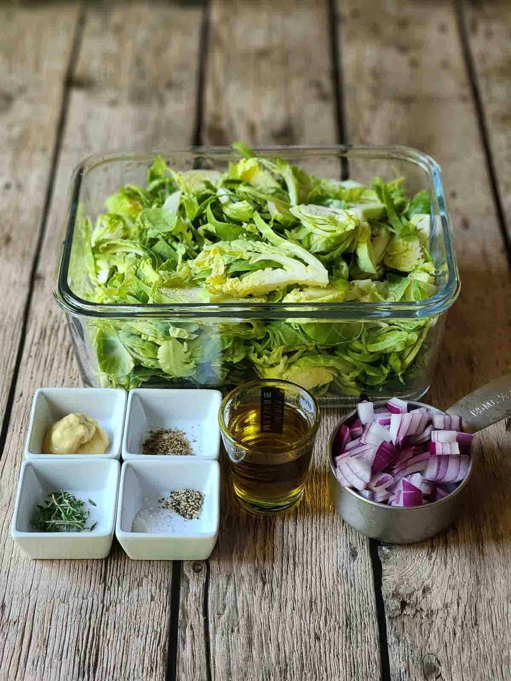 Ingredients for Brussel sprout hash on a wood surface.