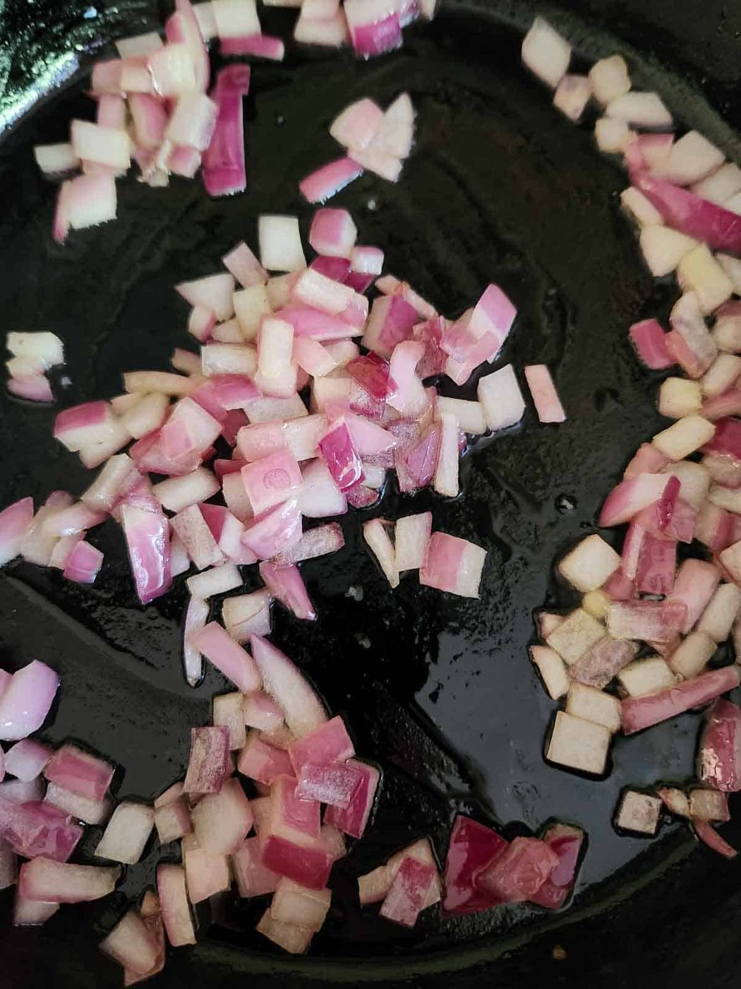 Sautee red onion in a black skillet.