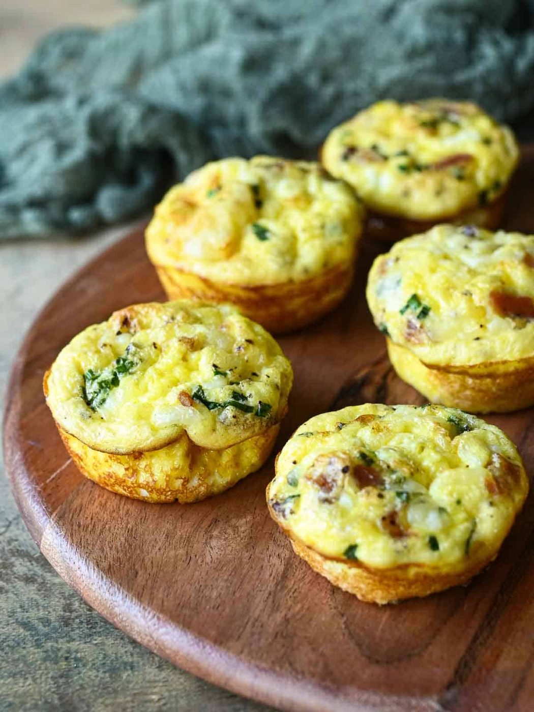 Five egg bites on a wood board.