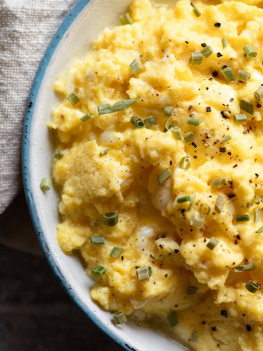 Overhead close-up of buttermilk scrambled eggs in a skillet.