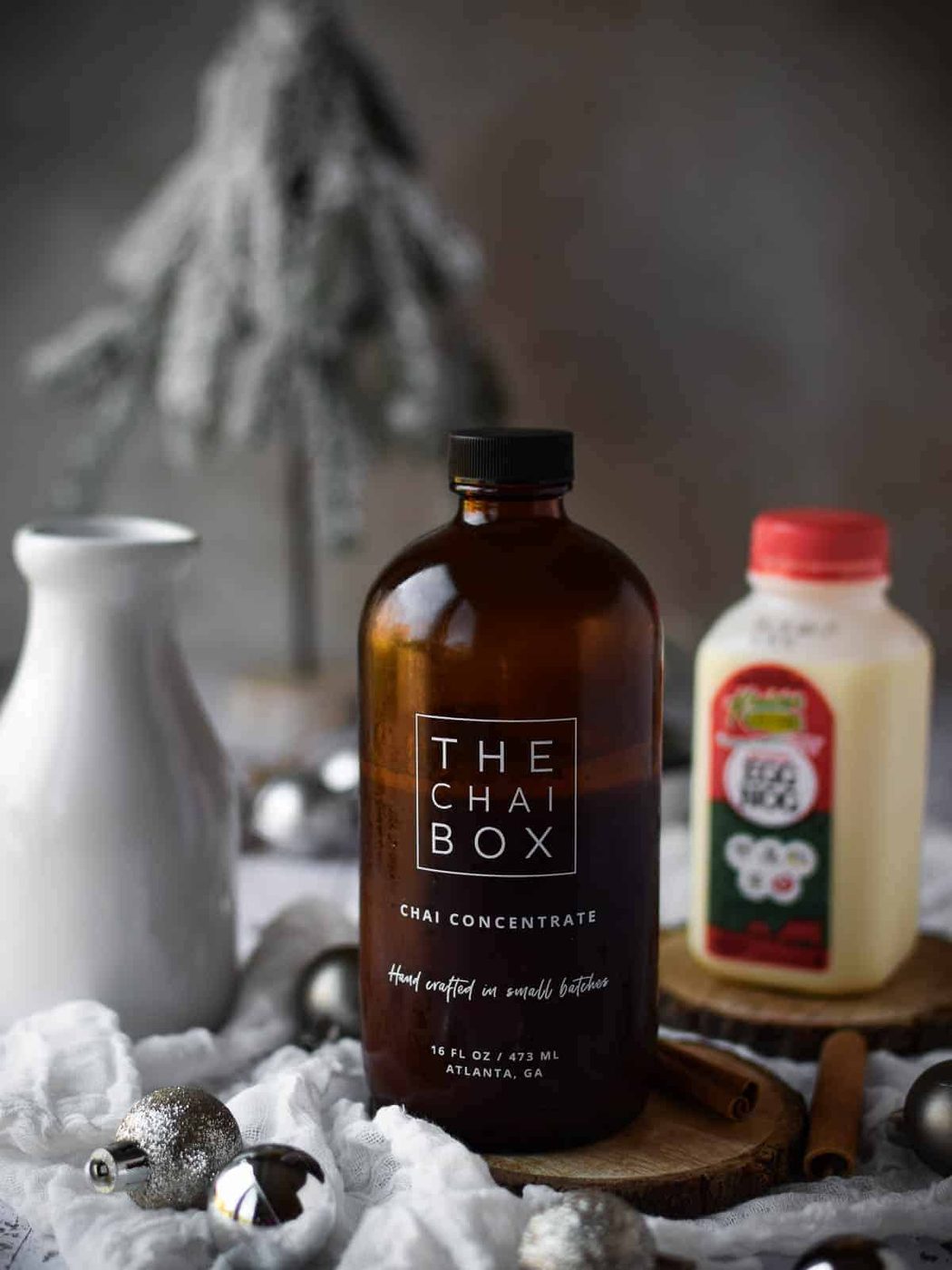 Chai concentrate and eggnog on a wooden surface.