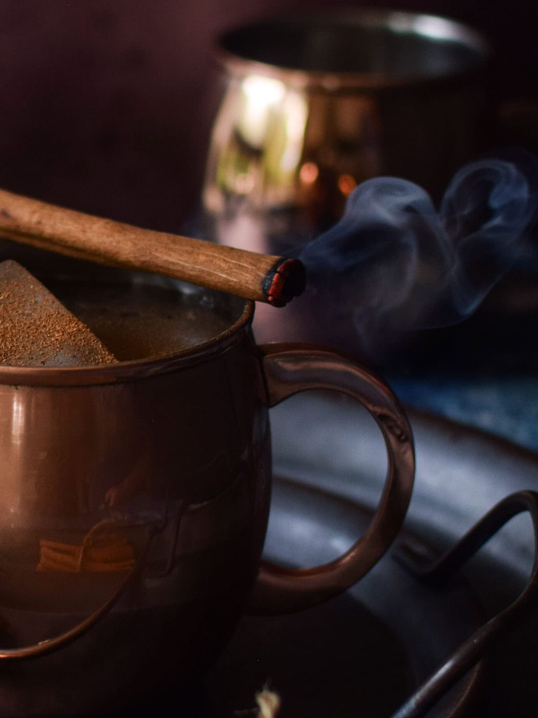 Cinnamon stick on a mug lit on fire.