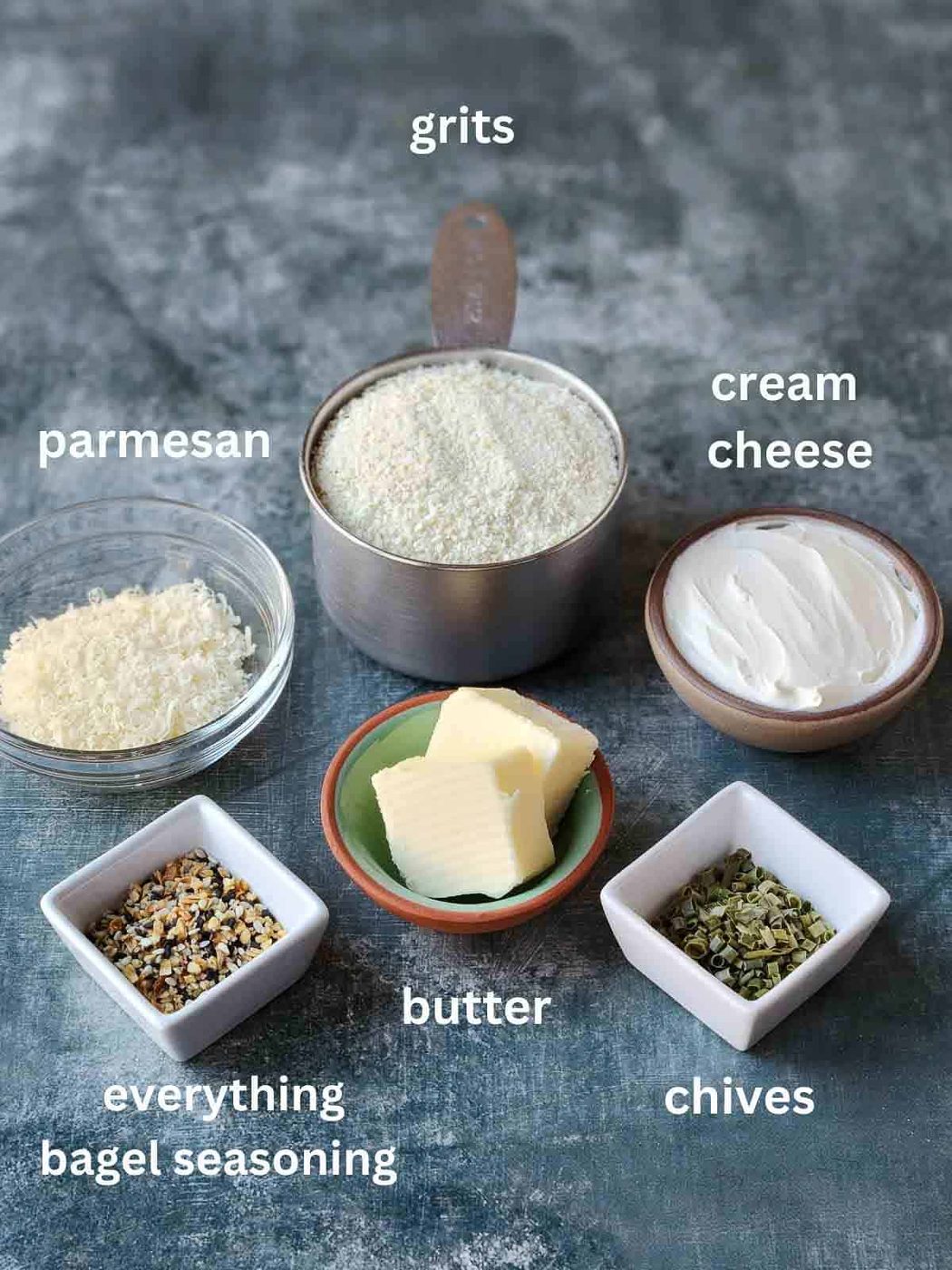 Overview of ingredients in bowls for grits on a grey surface.