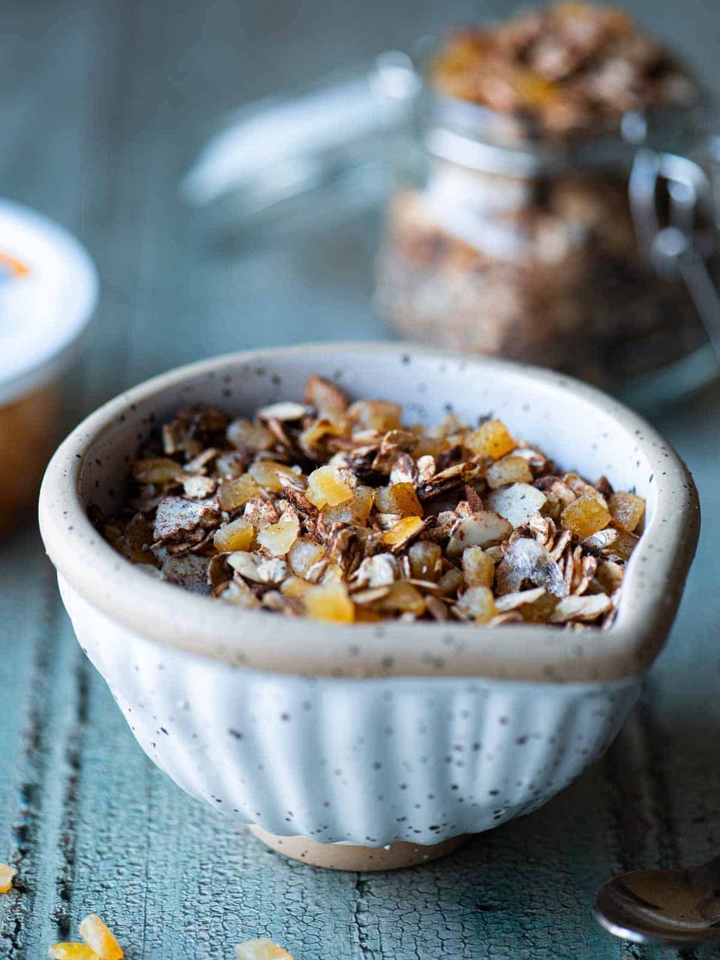 Chocolate muesli in a bowl on a blue surface.