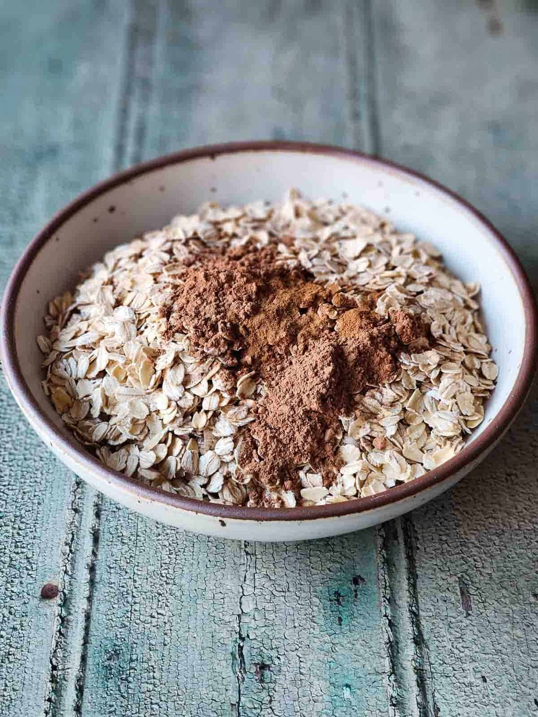 Oats and spices in a beige bowl.