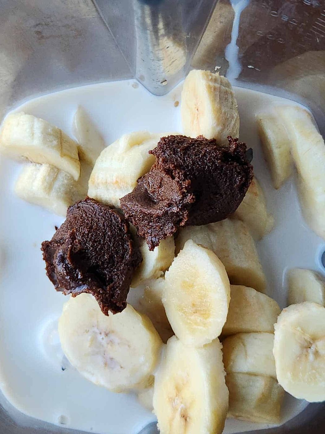 Bananas, milk and chocolate tahini in a blender.