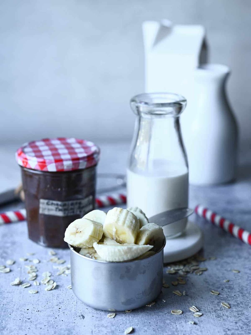 Ingredients for chocolate tahini smoothie on a grey background.