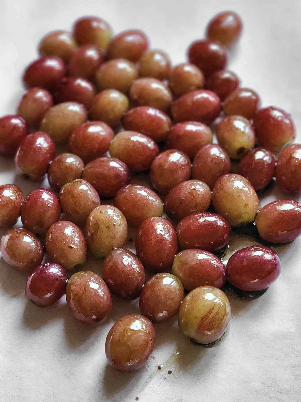 Marinated red grapes on parchment paper.