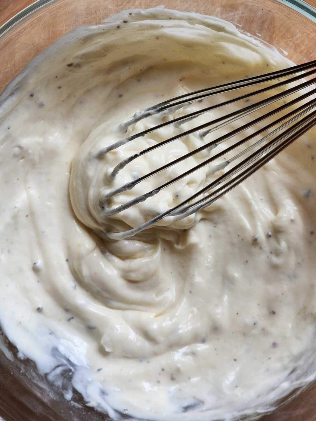 Dressing in a bowl with a whisk.