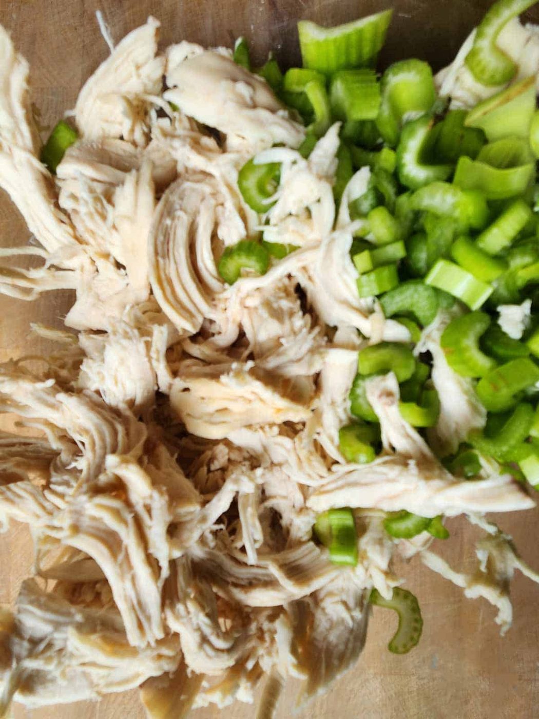 Chicken and chopped celery in a bowl.