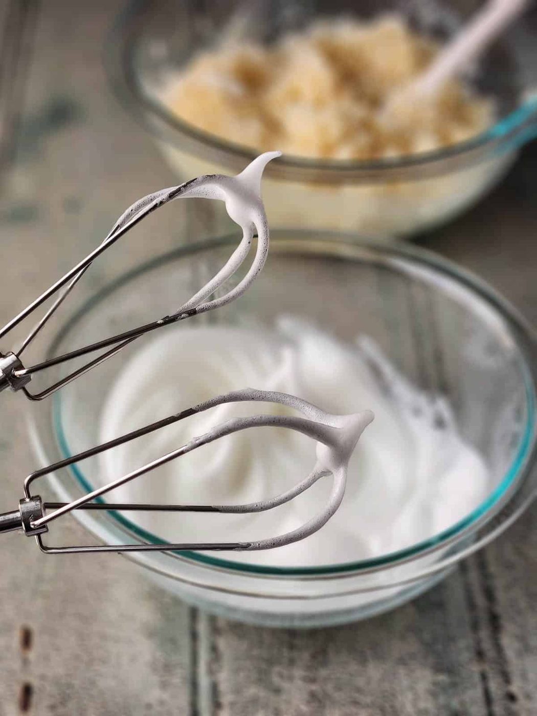 Two beaters showing whipped egg whites stiff peaks.