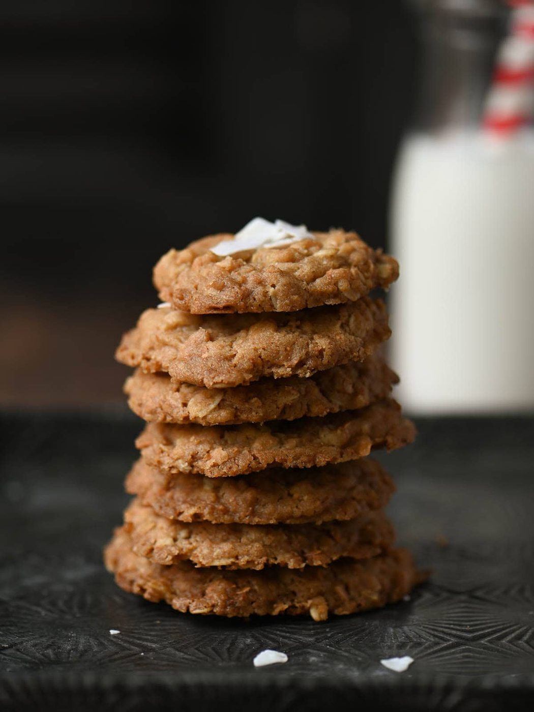 A stack of oatmeal cookies on a tin tray.