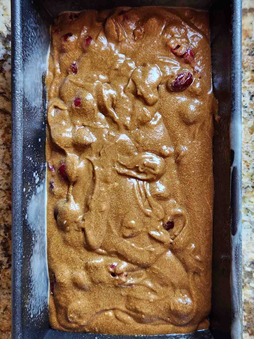 Batter in a loaf pan ready for baking.