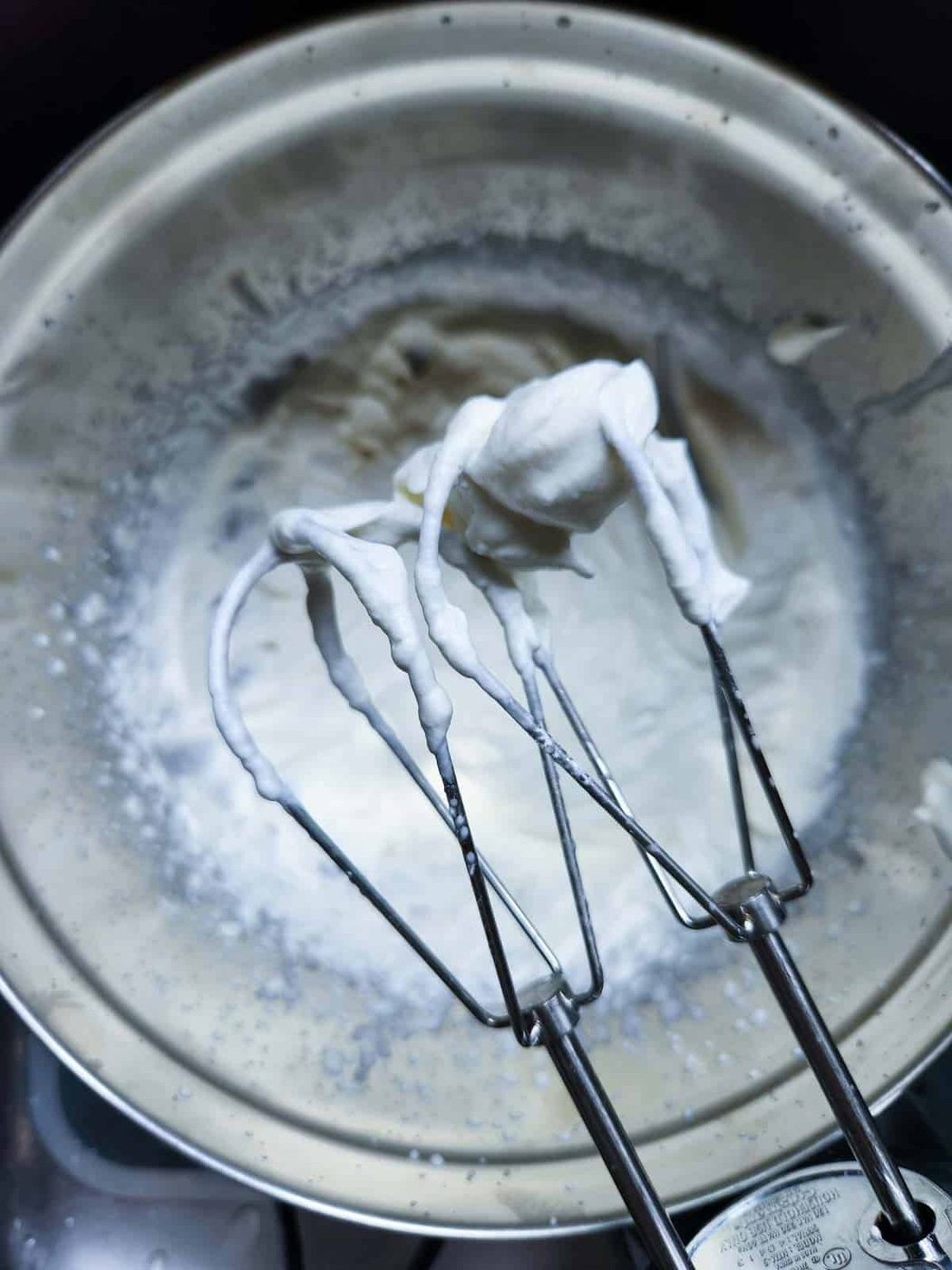 Whipped cream on beaters from a hand mixer.