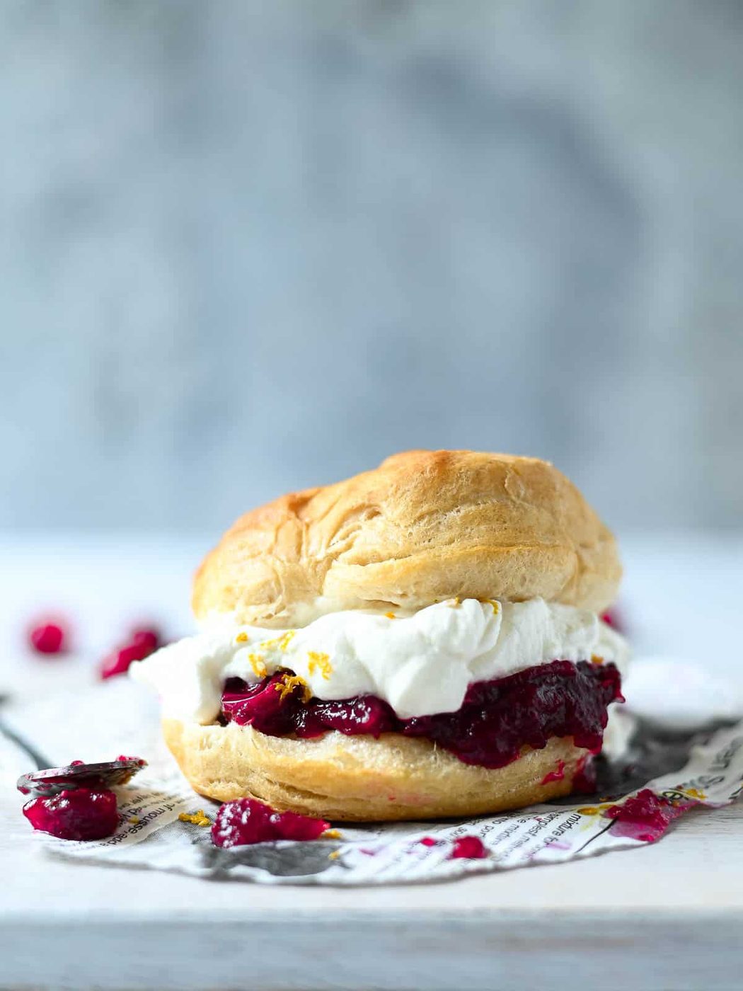 Eye-level view of cranberry shortcake with a spoon and cranberries next to it.