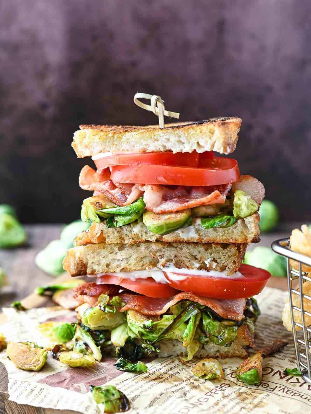 Brussel sprout BLT stacked on a wooden board.