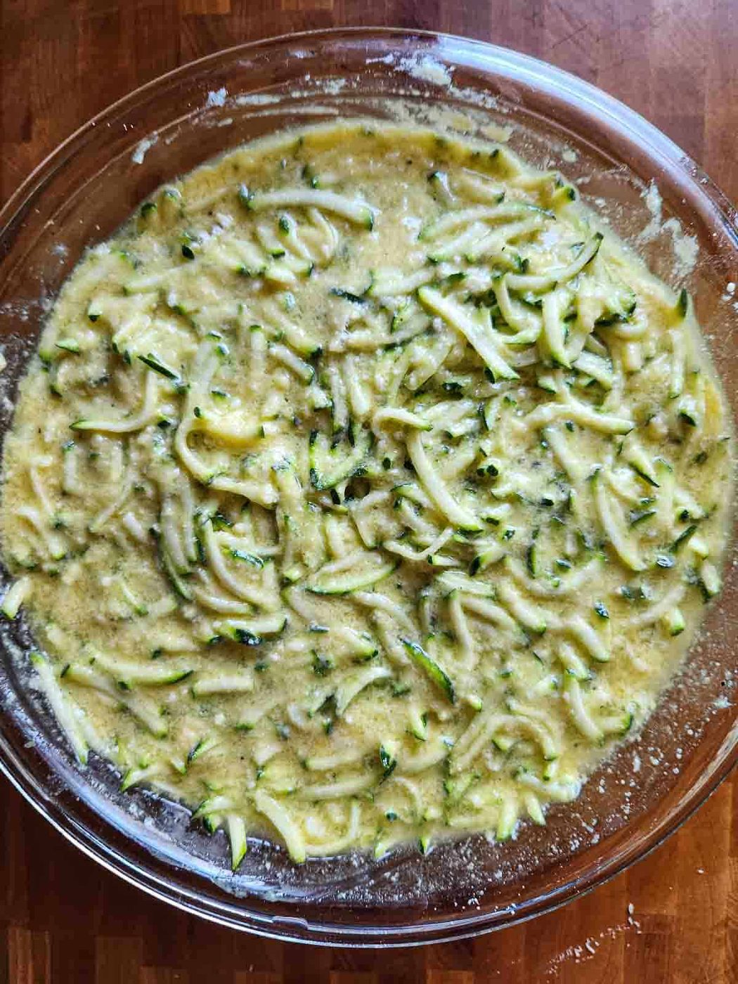 Mix for zucchini pie in a clear bowl.
