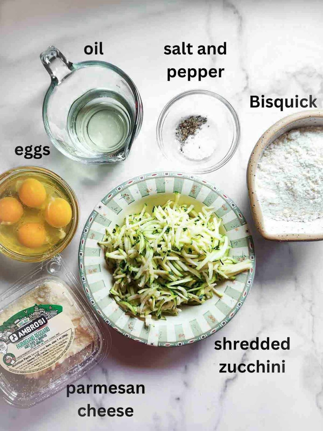Ingredients for crustless zucchini pie on a marble board.