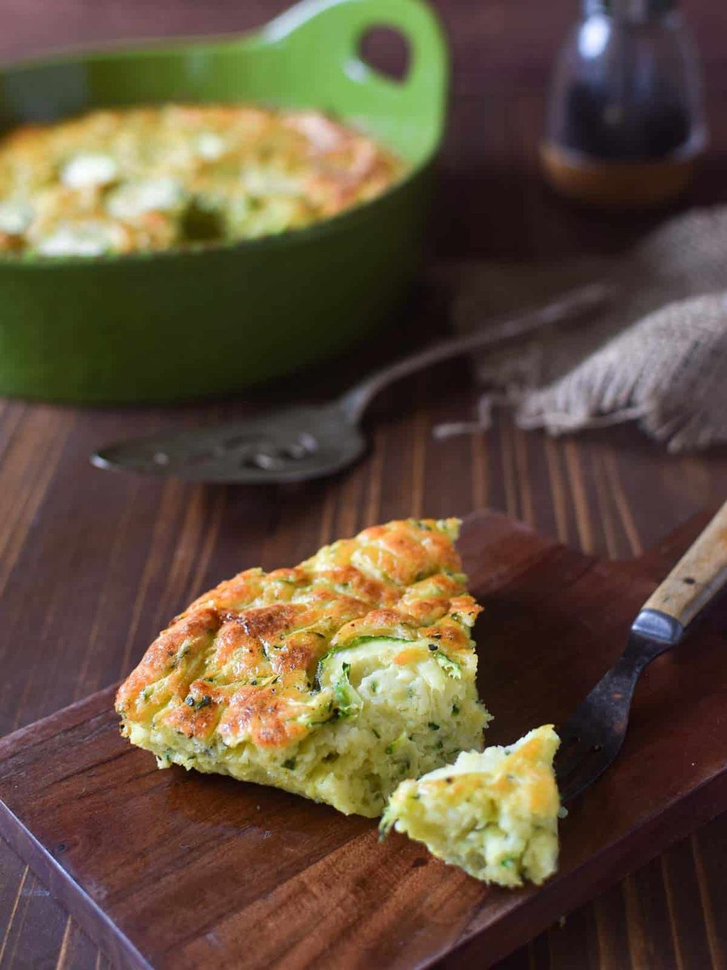 Slice of zucchini pie on a cutting board.