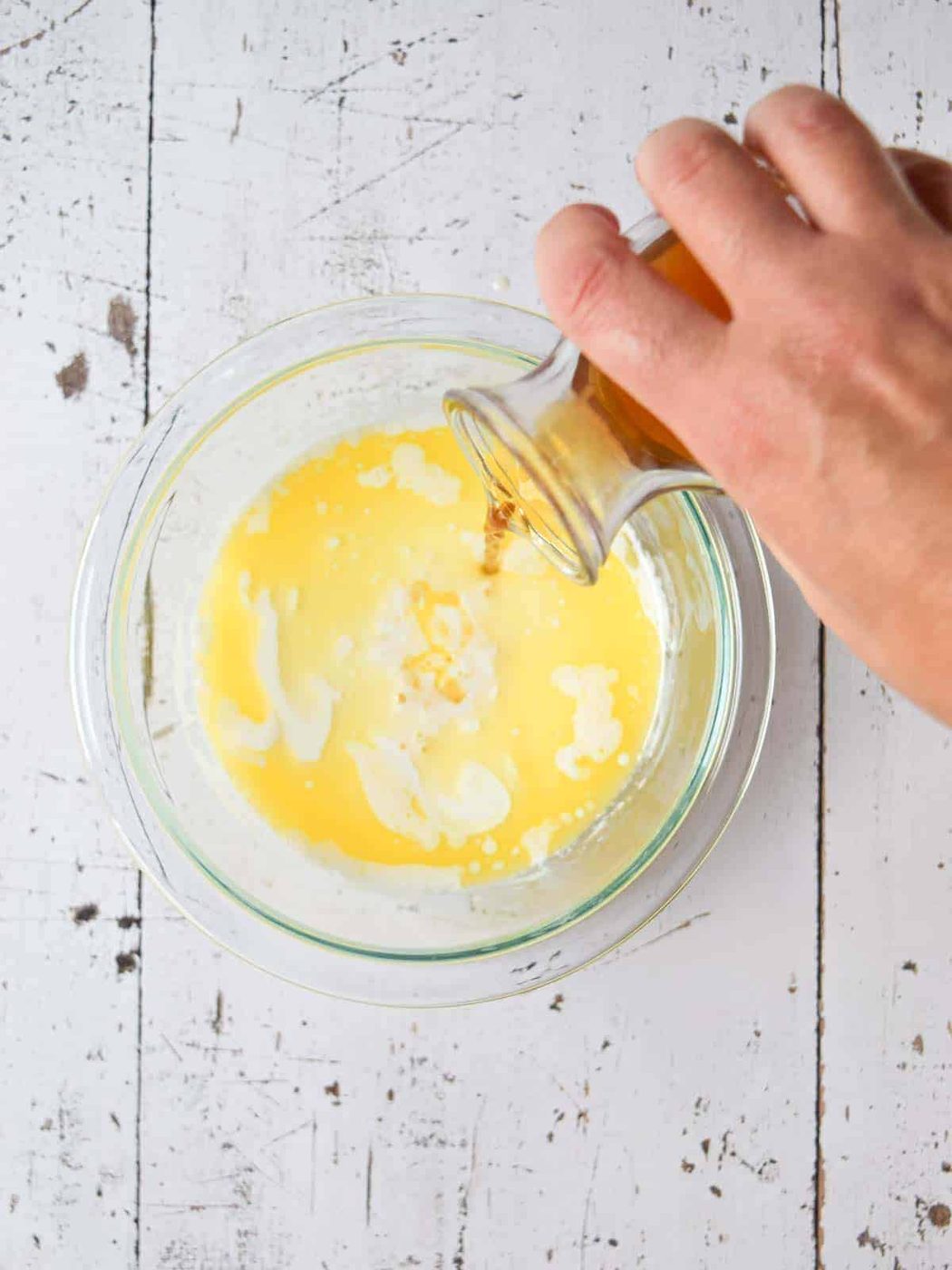 Wet ingredients in a clear bowl for pancakes.