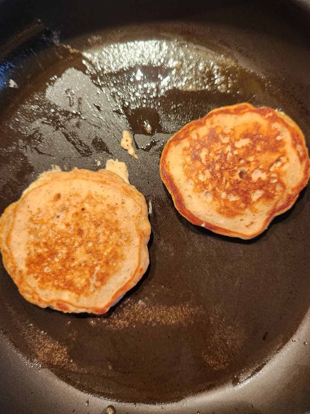 Cooked pancakes in a skillet.