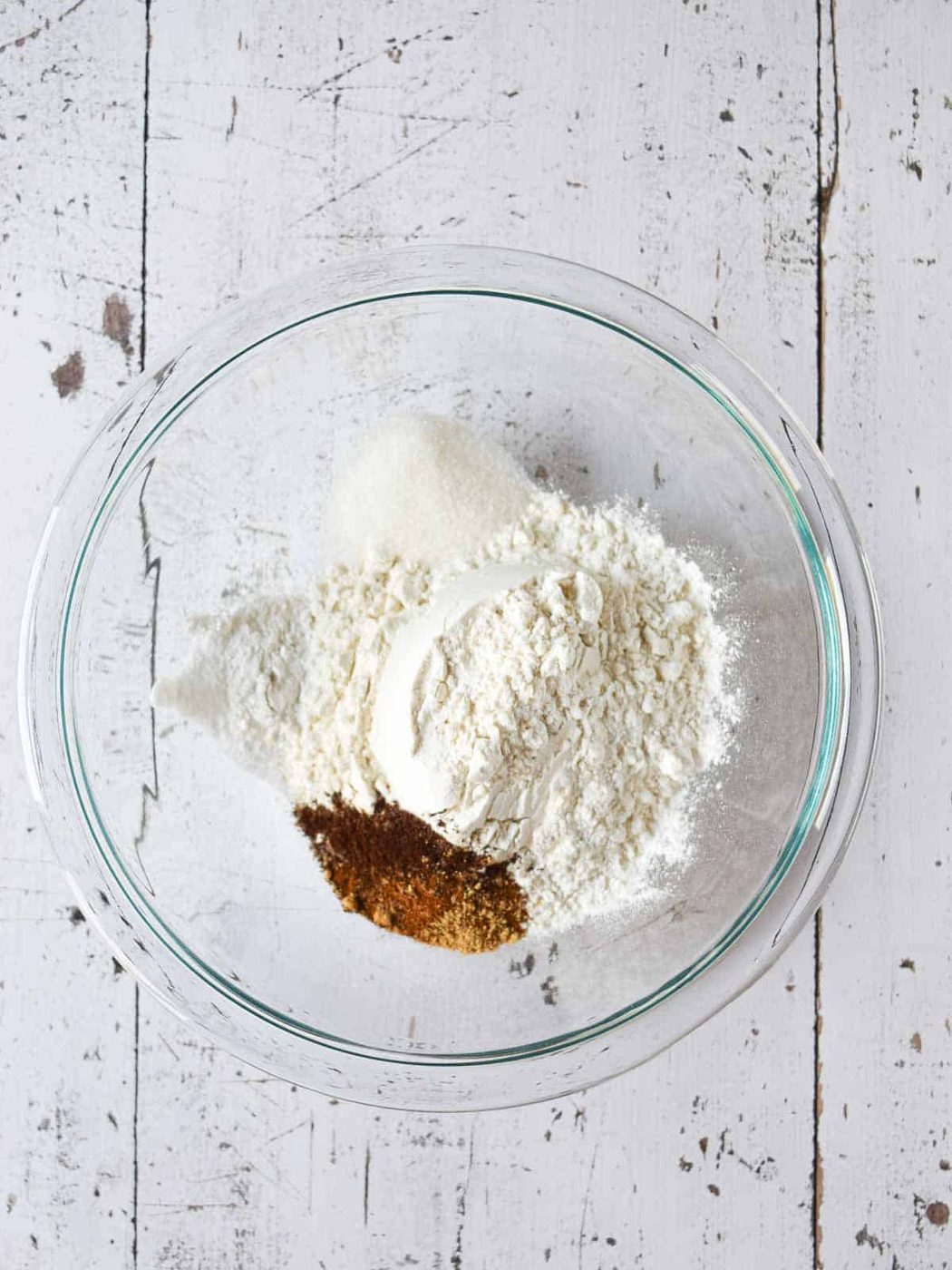Dry ingredients in clear bowl for chai spiced pancakes.