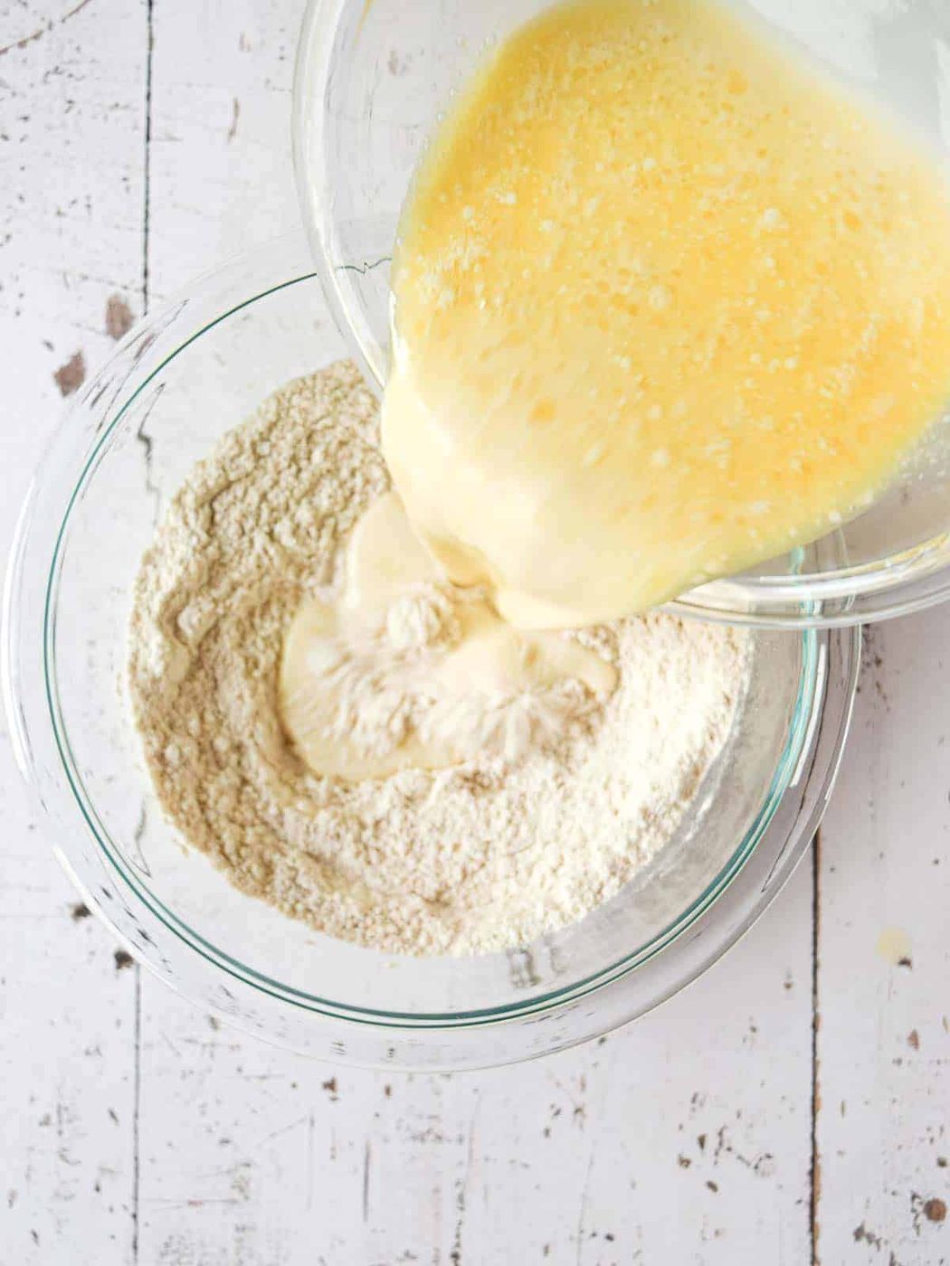 Pouring wet ingredients into dry ingredients for pancake recipe.