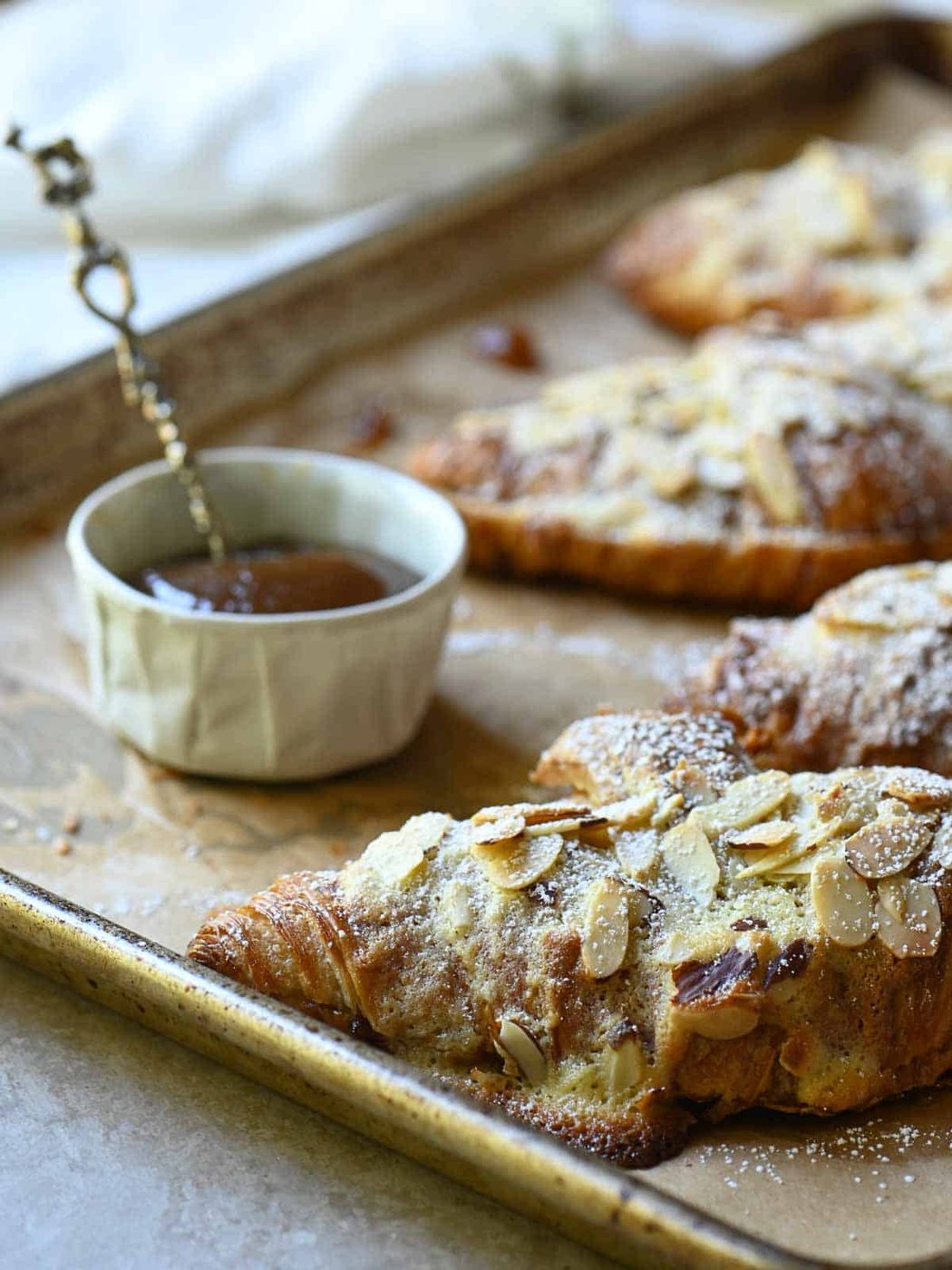 Almond croissants and apple butter on a baking tray.