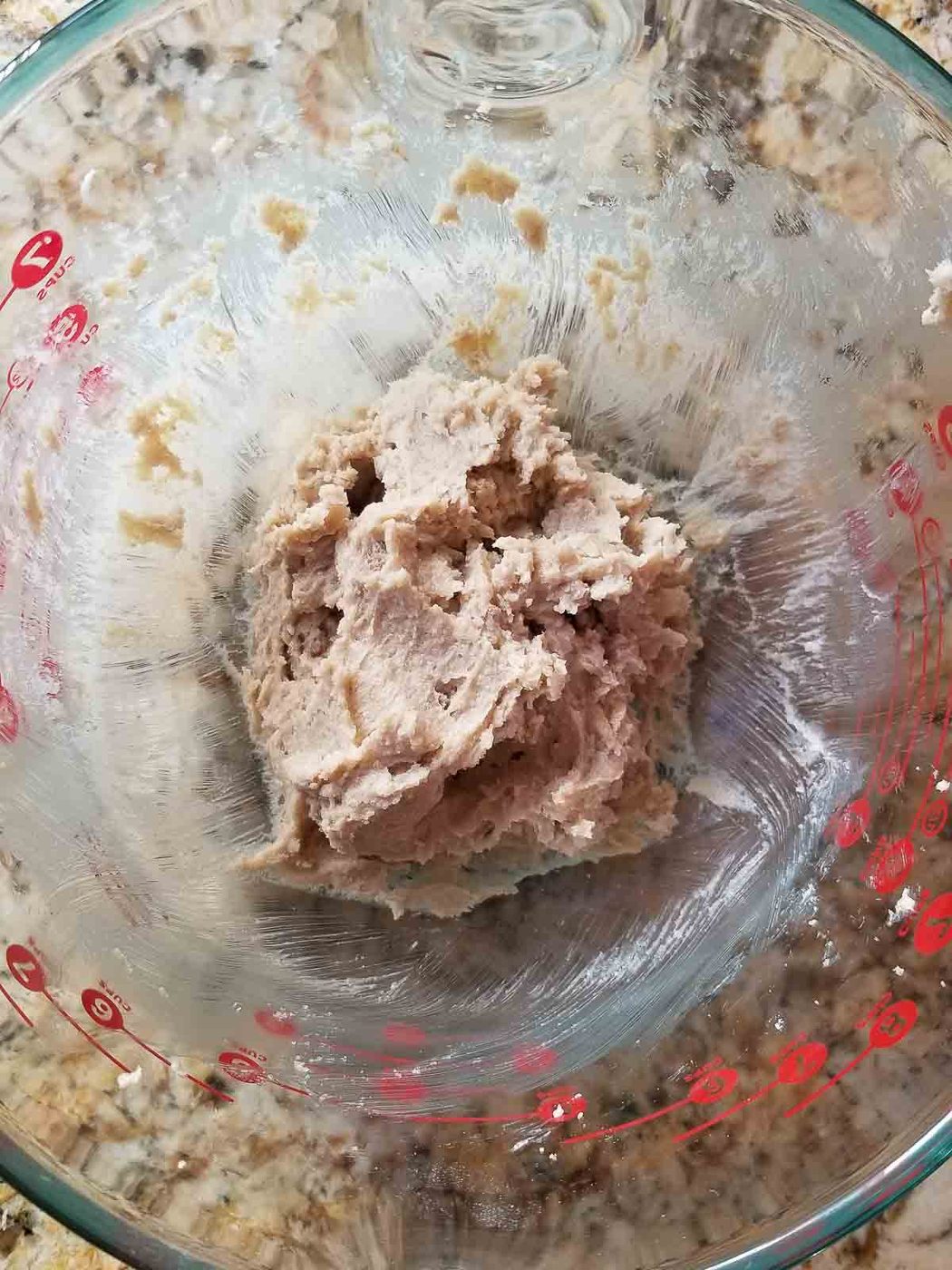 Process shot showing butter and sugar creamed together in a bowl.