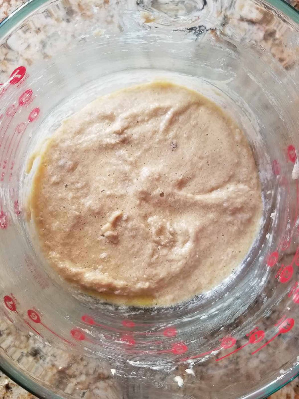 Process shot showing sugar mixed with eggs, zest and vanilla extract in a bowl.