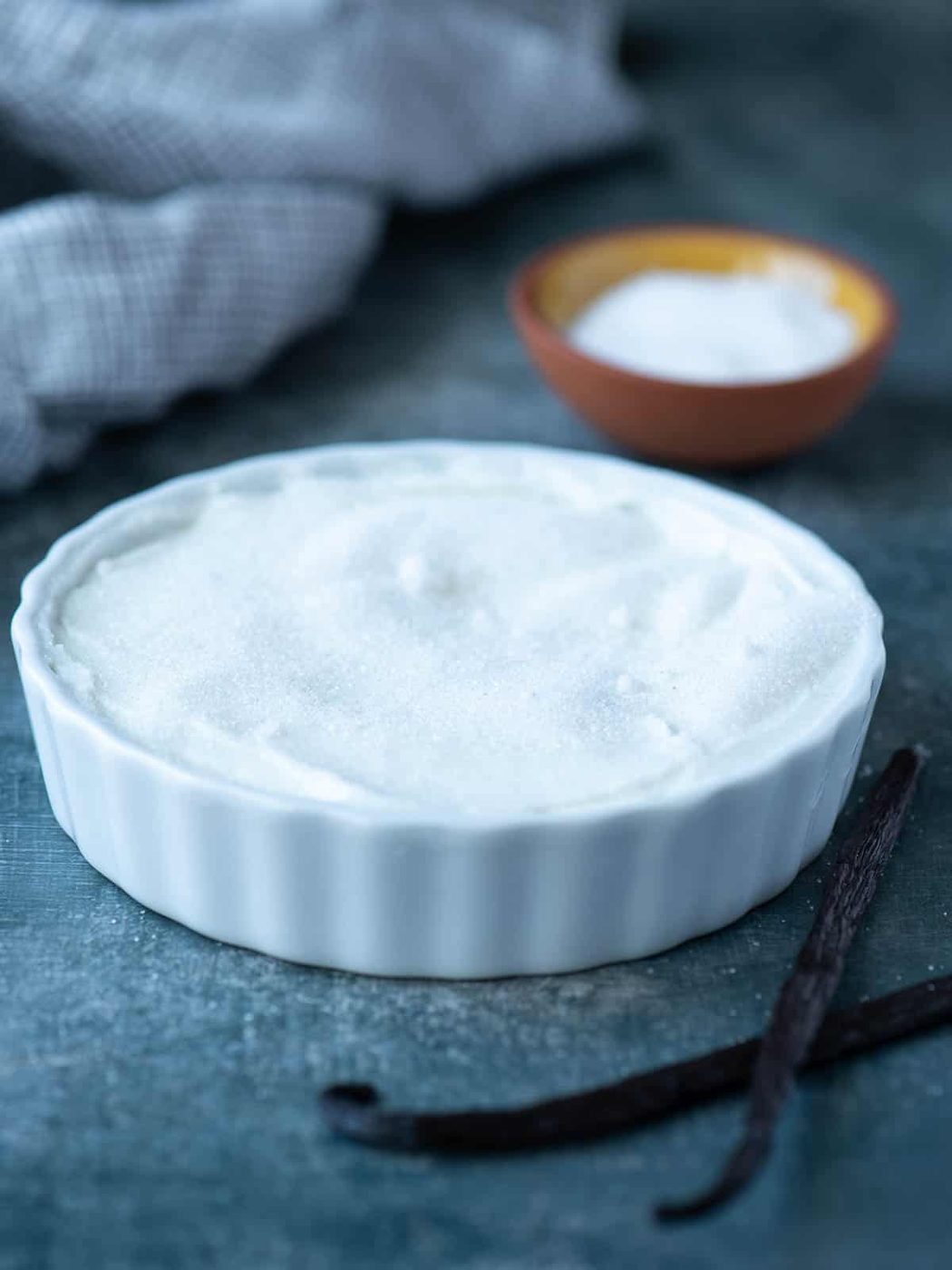 Sugar over on top of yogurt in a white ramekin.
