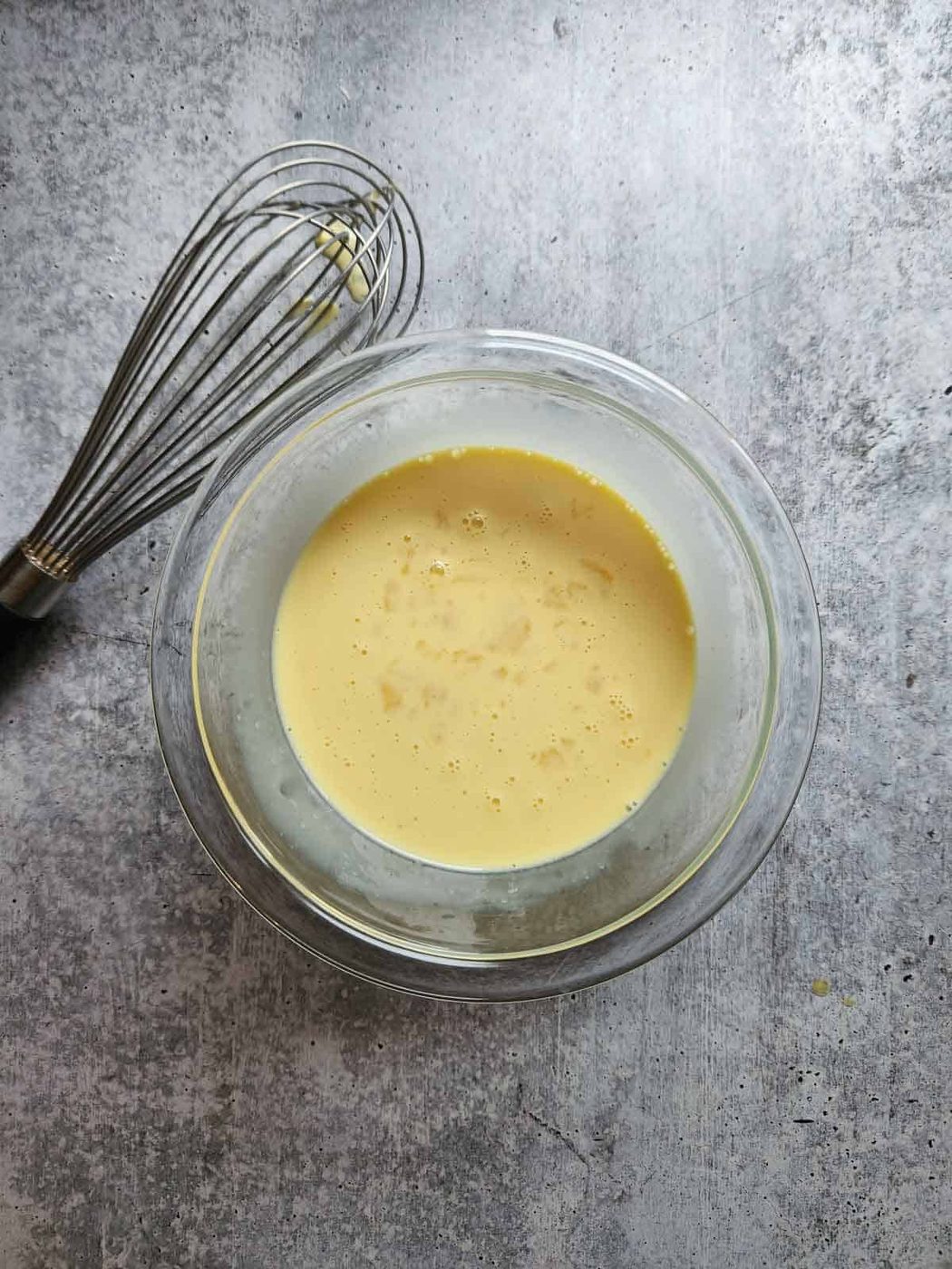 Wet ingredients in a bowl for eggnog waffles.