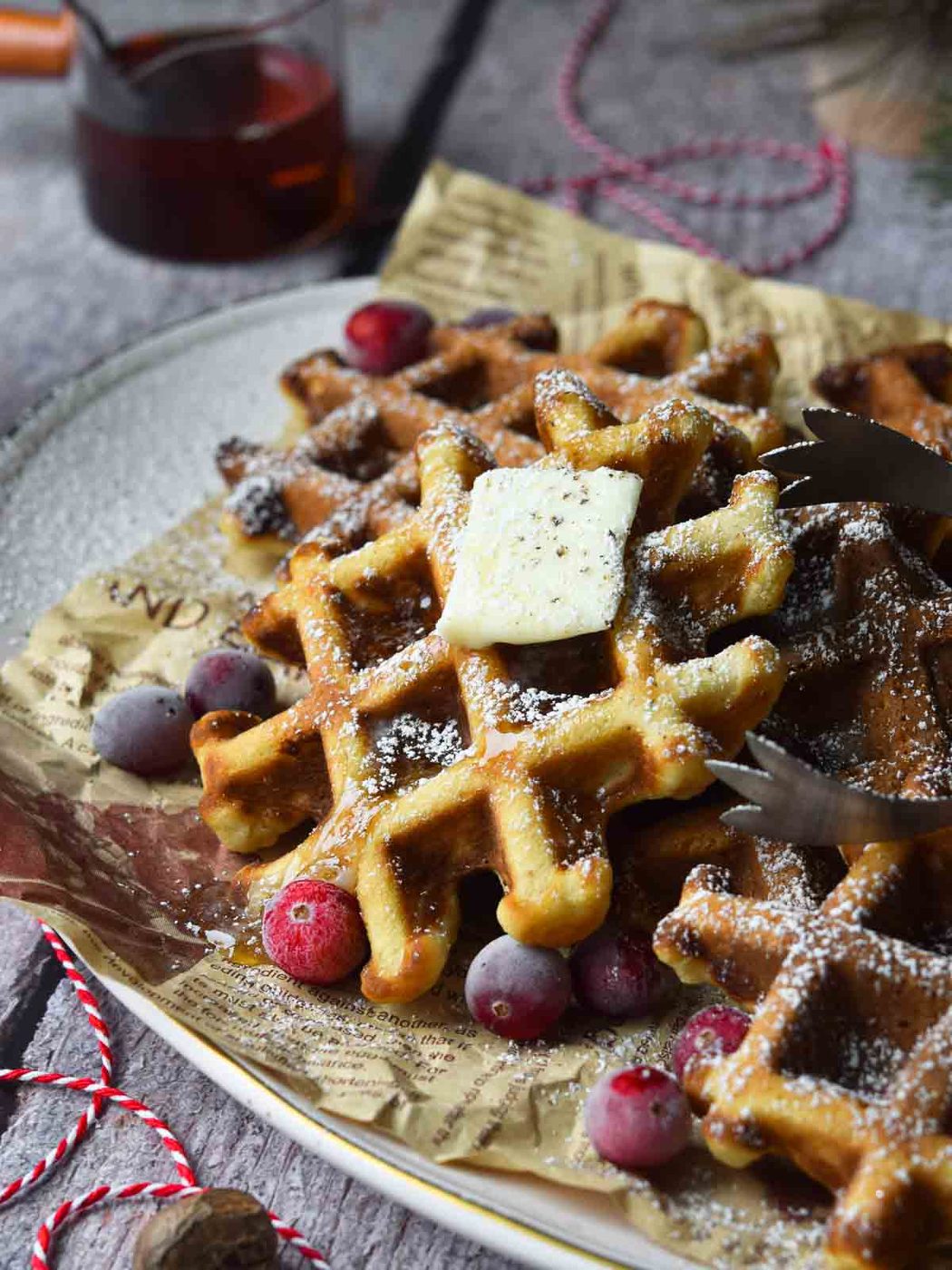 Close-up of eggnog waffles on a platter with cranberries around it.
